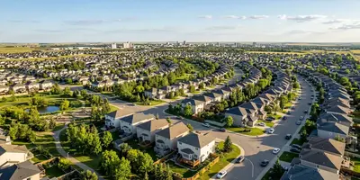 Aerial view of a Saskatchewan suburban neighbourhood, family homes and green trees on a summer afternoon