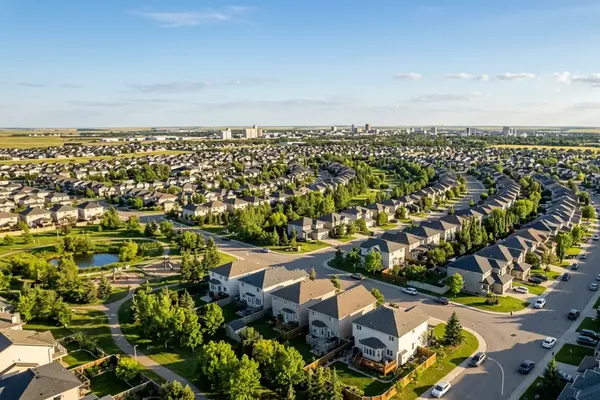 Aerial view of a Saskatchewan suburban neighbourhood, family homes and green trees on a summer afternoon