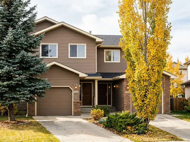 1980s semi-detached home with spruce and yellow fall poplar in Forest Grove, Saskatoon