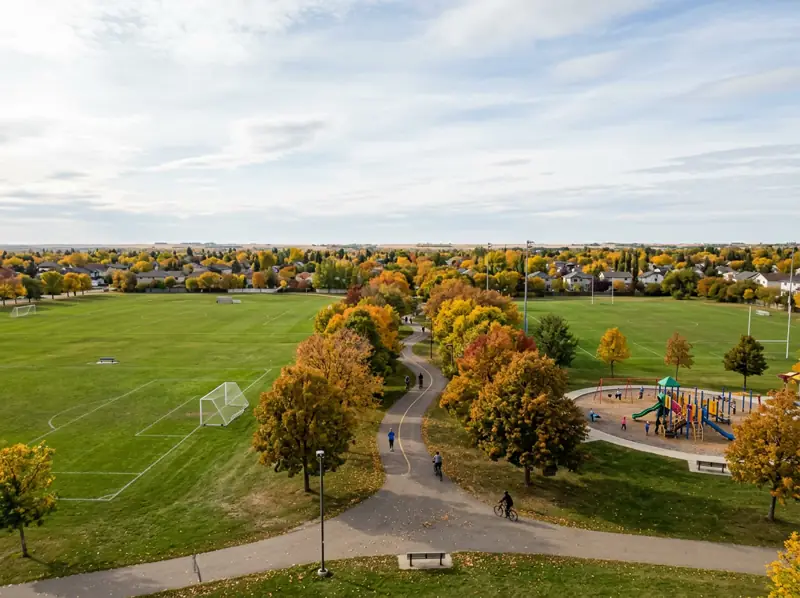 Sports fields, playground and tree-lined path in autumn colours at a park in Pacific Heights