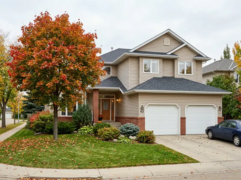 1990s two-storey home with a double garage and an orange fall tree in Silverspring, Saskatoon
