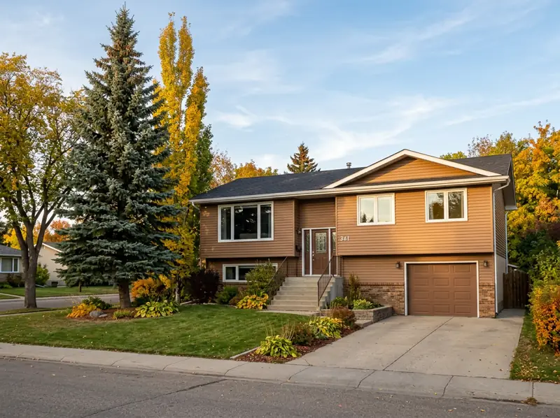 1980s bi-level home with a raised entry, front garage and fall trees in Silverwood Heights, Saskatoon